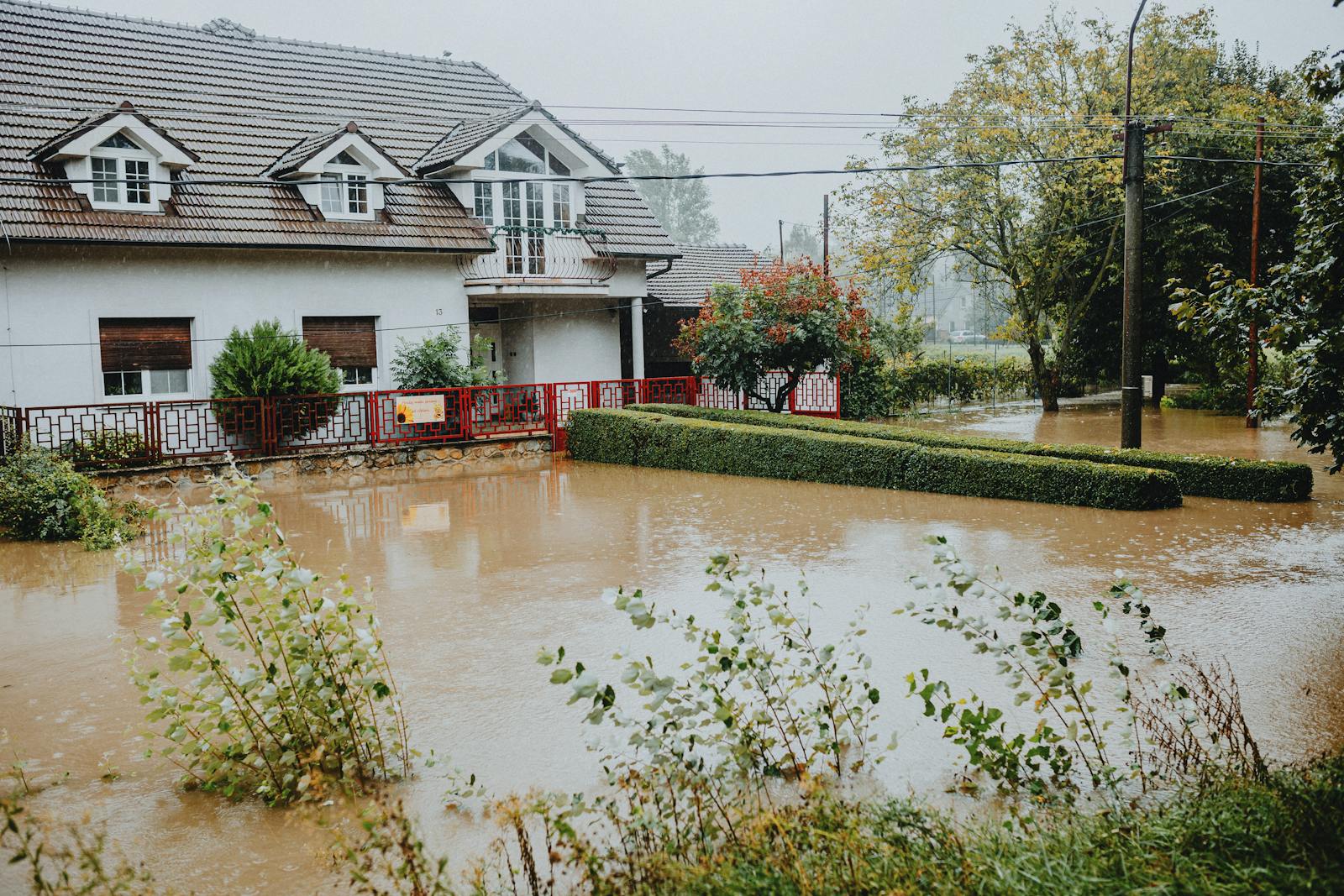A suburban house surrounded by flood after heavy rain, showing impact of natural disaster.